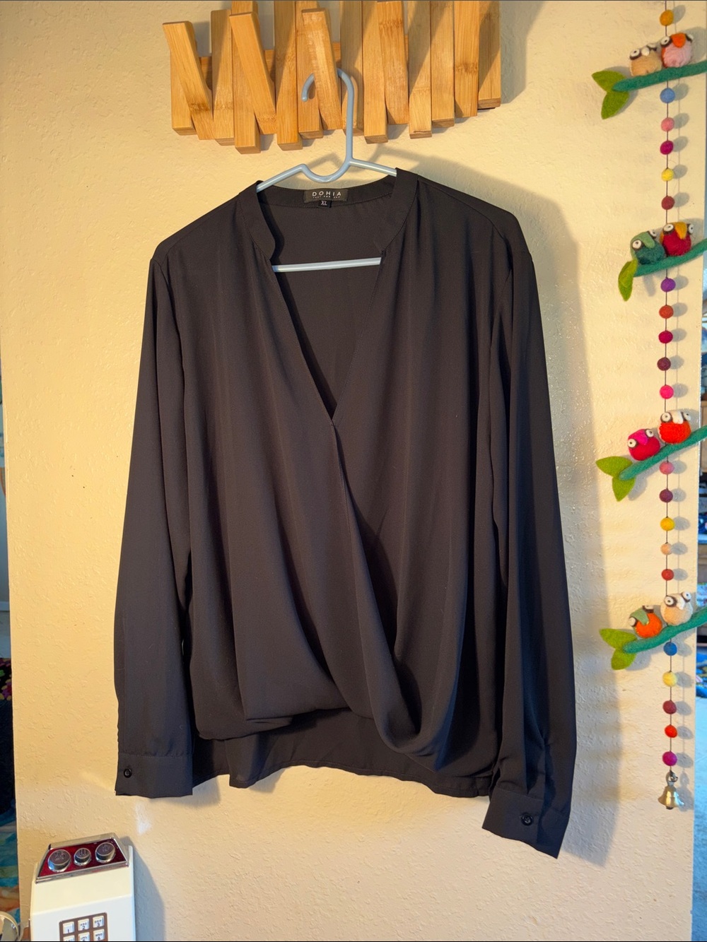 EUC black DOHIA brand blouse features a wrap-front drape design with a V-necklin